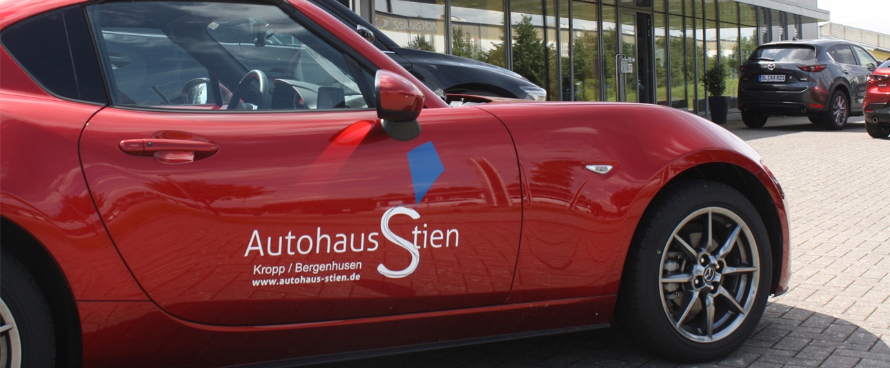 ein rotes Auto vor dem Autohaus Stien